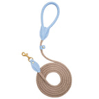 Top-down view of the coiled CacheMio & CHOUCHOÚ walking leash, highlighting the serene blue leather details against the earthly beige rope core.