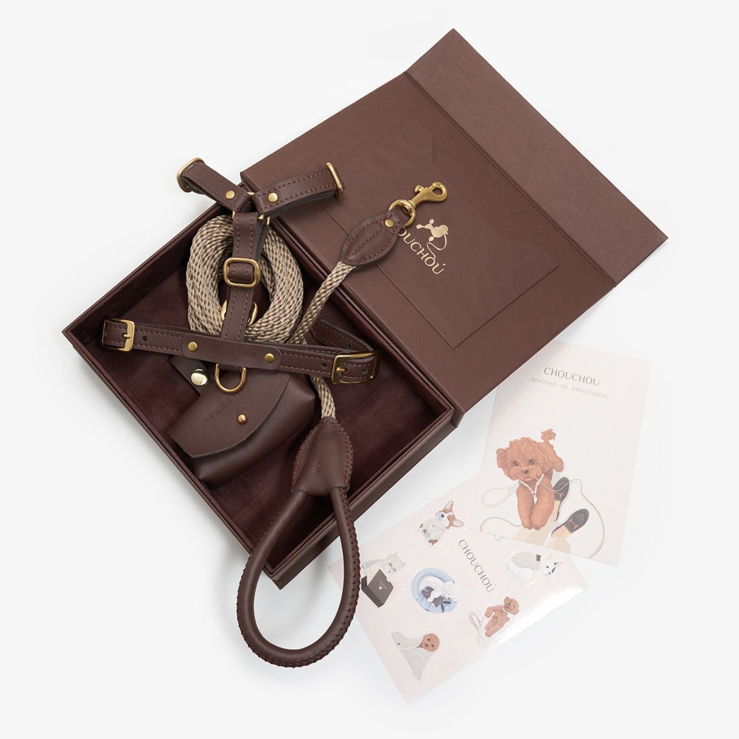 Top-down view of the chocolate brown leather dog walking set by CacheMio & CHOUCHOÚ in a premium gift box with care cards.