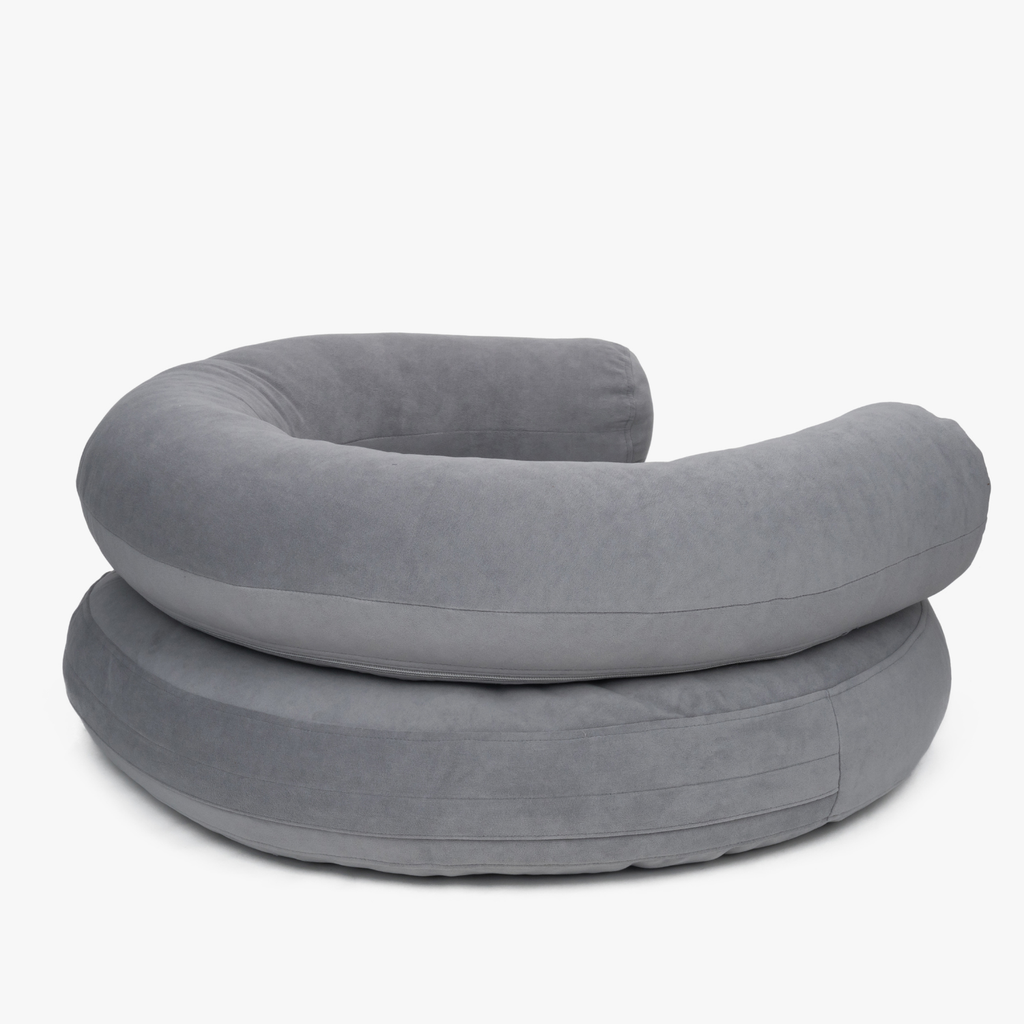 Concealed rear zipper lines maintain the pristine minimalist silhouette of the folded grey orthopedic resting space by CacheMio.