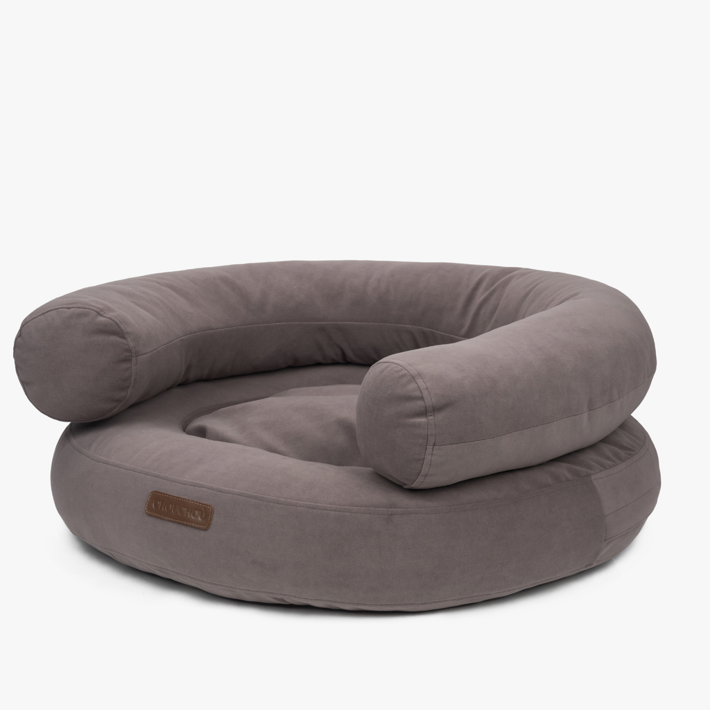 Thick supportive bolsters and velvet-touch upholstery define the deep chocolate-toned pet lounge, presented in a crisp studio stance.