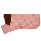 Engineered for elegant protection, this blush-toned pet vest rests in a folded side angle. The image captures precise tailoring and a distinct contrast between the pastel shell and the dark velvet neck trim.