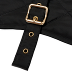 Extreme close-up of the striking gold-tone brass buckle against the deep black fabric of the CacheMio & CHOUCHOÚ premium pet outerwear.