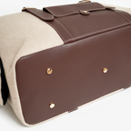 Heavy-duty solid brass protective feet anchor the structured dark brown leather base, shielding the luxury accessory from urban pavement wear.