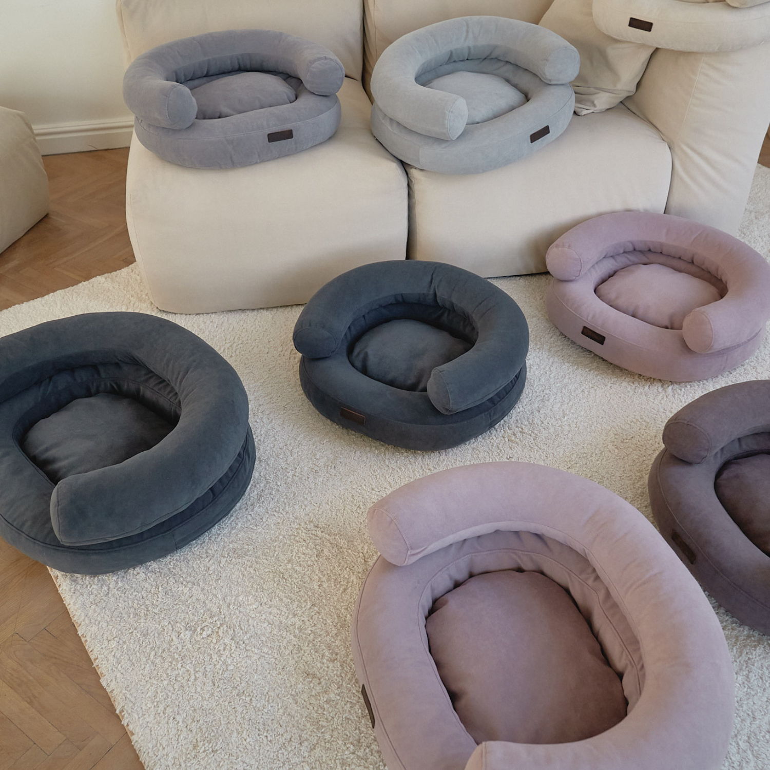 Scattered arrangement of plush resting areas across a light-flooded modern living space, highlighting how the neutral canine sofas effortlessly integrate with contemporary home decor.