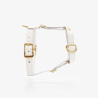 Spotlighting the pristine white leather profile and golden brass hardware, this anatomical chest strap sits flawlessly against a stark studio background.