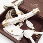 Macro view of the CacheMio & CHOUCHOÚ milk white leather dog walking set, highlighting the solid brass D-ring and meticulous stitching.