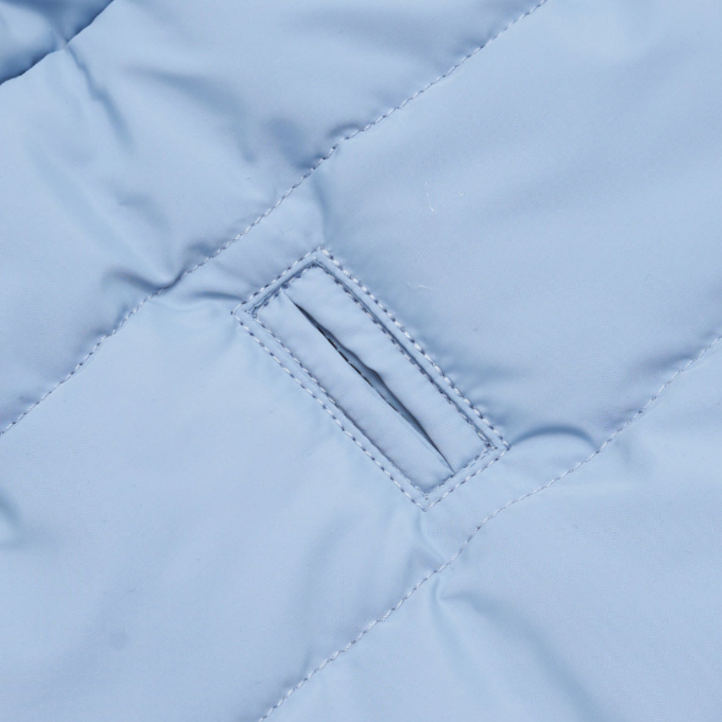 Precision stitching frames the reinforced harness portal cut into the waterproof textile. This architectural detail allows seamless lead attachment without compromising the thermal integrity of the coat.