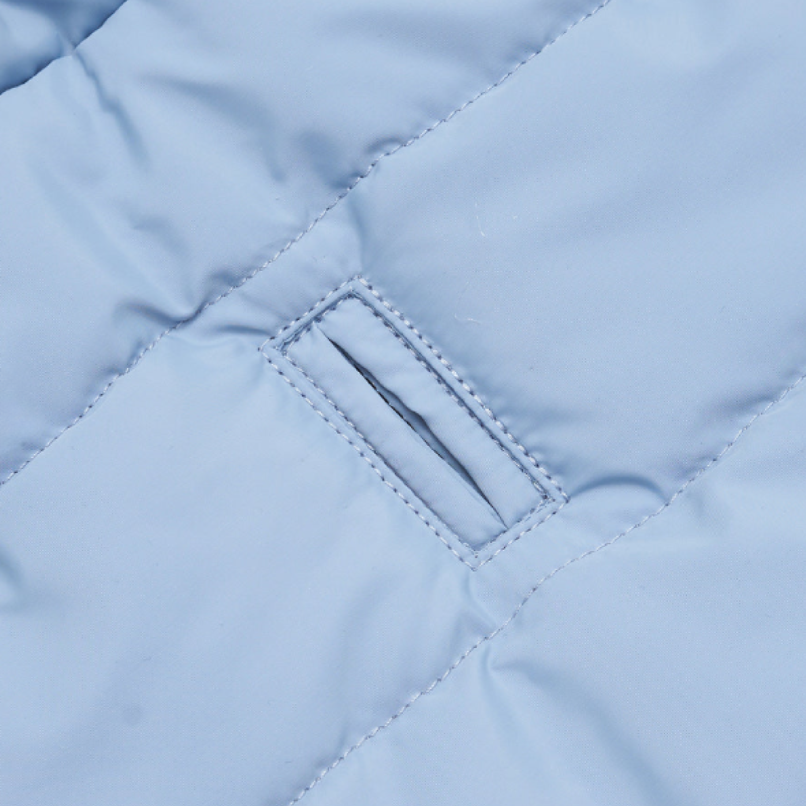Precision stitching frames the reinforced harness portal cut into the waterproof textile. This architectural detail allows seamless lead attachment without compromising the thermal integrity of the coat.