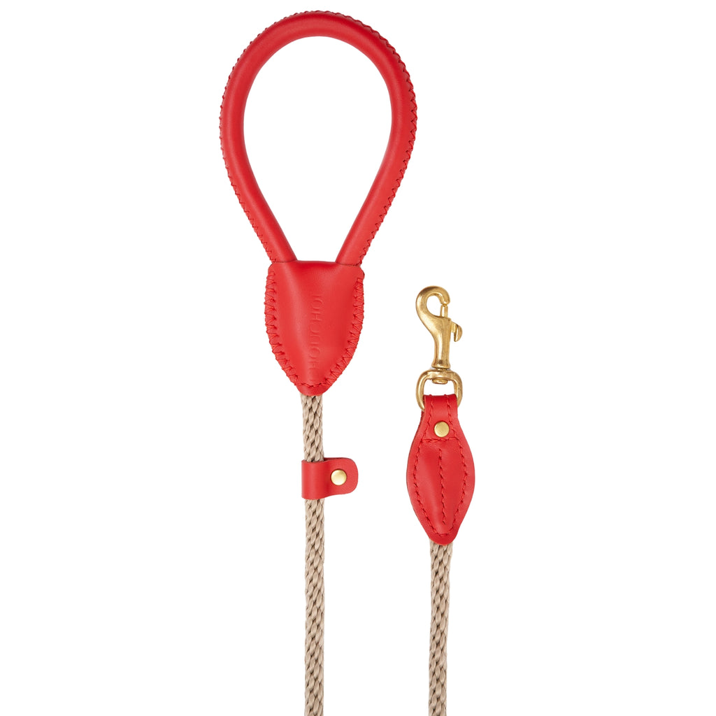Minimalist flatlay of the Classic Red dog walking leash by CacheMio & CHOUCHOÚ, showcasing its bold design and shock-absorbing beige construction.