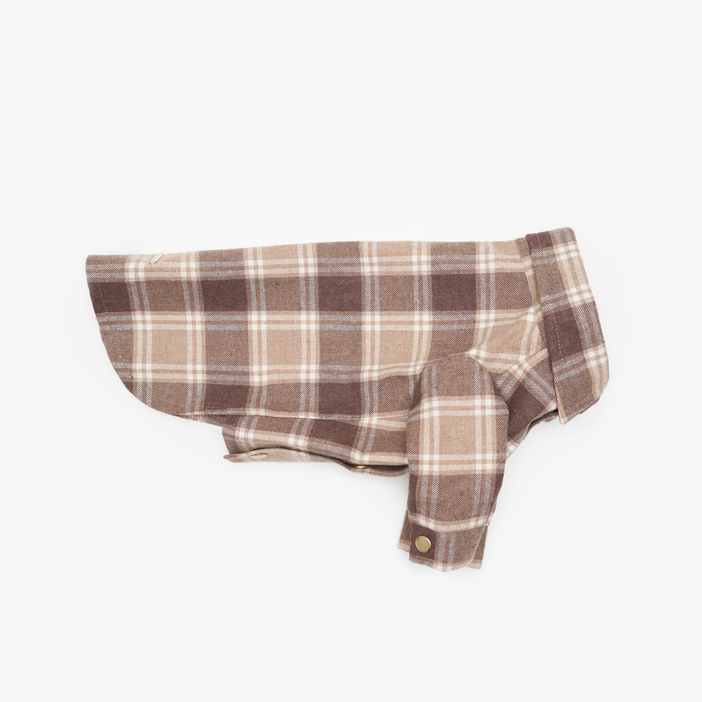 Side profile of a folded brown tartan dog shirt on a white background, highlighting the tailored sleeve construction and structured collar.