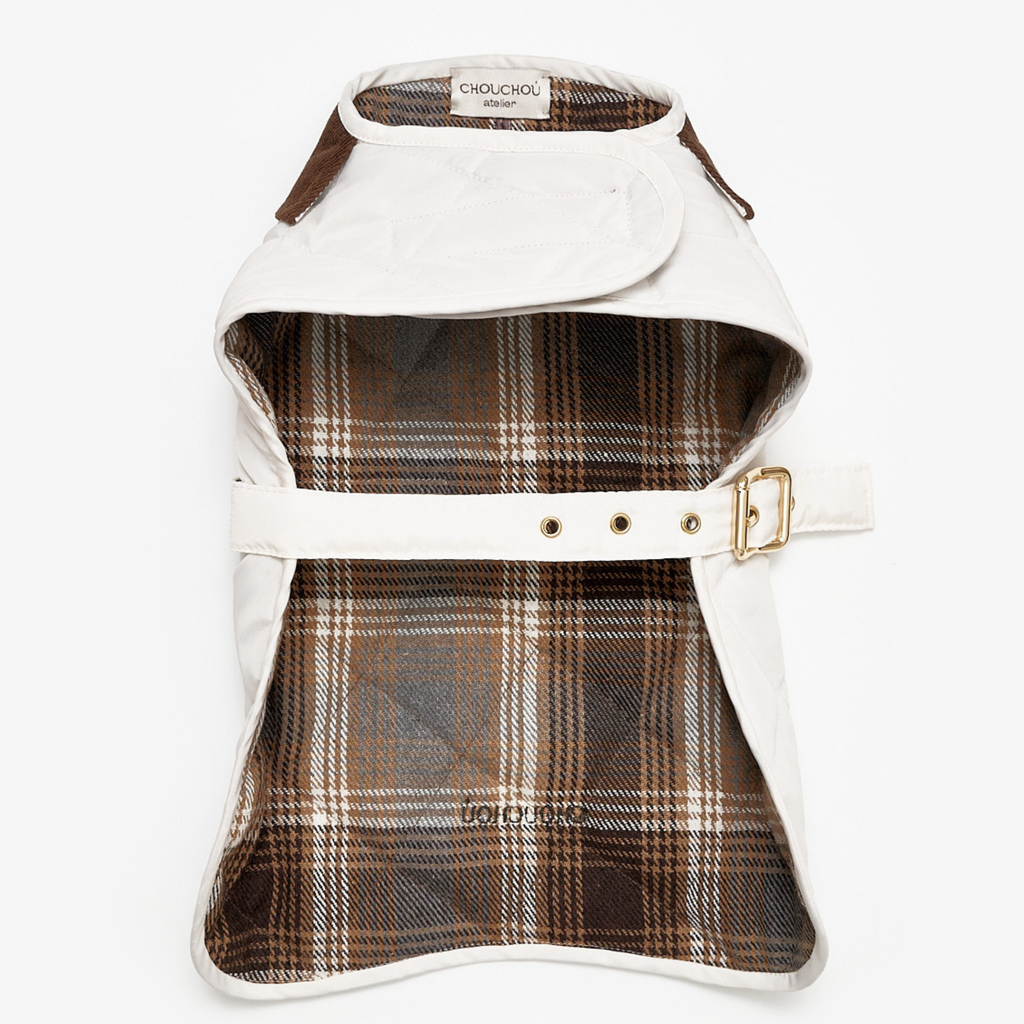 Unfurled to reveal its intricate interior, the garment exposes a classic brown and white plaid cotton lining. This breathable thermal layer is bordered by the pristine, water-resistant outer fabric.
