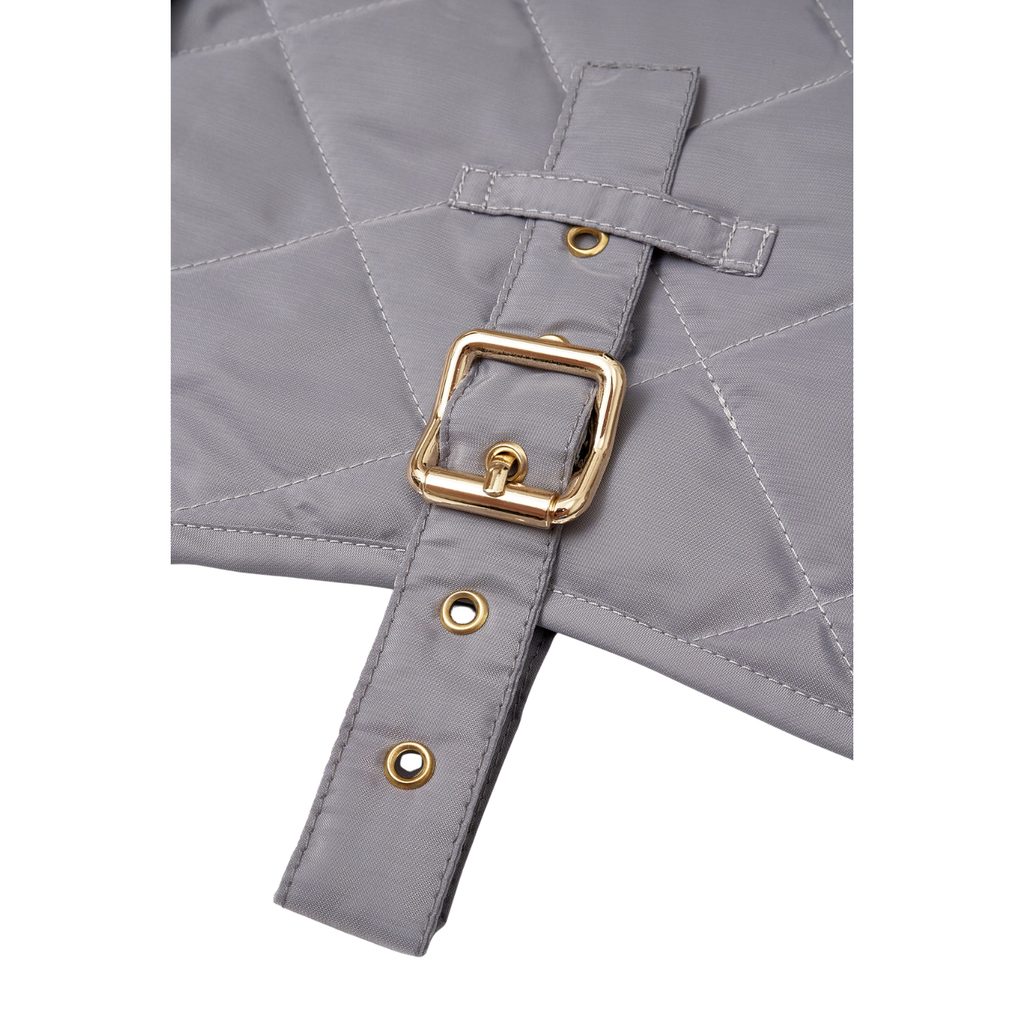 Extreme close-up of the heavy-duty solid brass hardware and meticulous stitching on the CacheMio x CHOUCHOÚ weather-ready dog apparel.