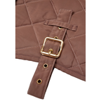 Macro photography detailing the heavy-duty solid brass buckle and reinforced strap construction on the CacheMio x CHOUCHOÚ heritage dog coat.