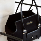 Structured top handles frame the plush, light-blocking interior sanctuary of the black designer pet tote, engineered for secure and stylish urban mobility.