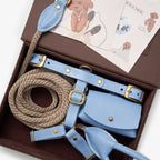 Unboxing the CHOUCHOÚ light blue leather dog accessories set, elegantly packed with signature dog illustration care cards.