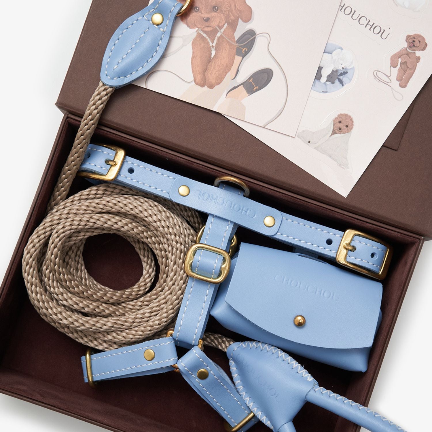 Unboxing the CHOUCHOÚ light blue leather dog accessories set, elegantly packed with signature dog illustration care cards.