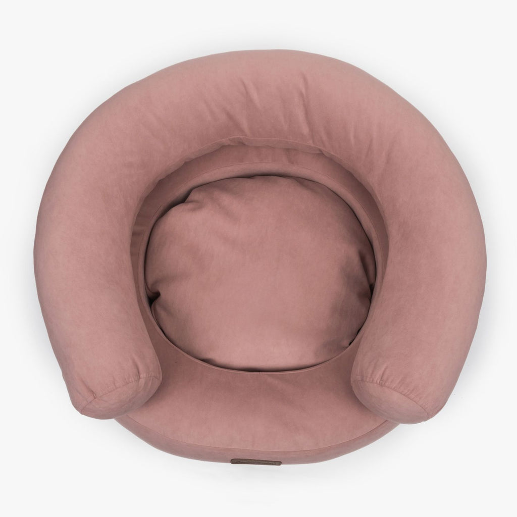 Top-down view of the pink Marshmallow luxury dog bed by CHOUCHOÚ, showcasing its cozy contoured shape and hypoallergenic resting area.
