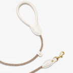 Pristine ivory leather dog leash handle and solid brass clasp by CacheMio & CHOUCHOÚ, connected by a durable light beige rope core.