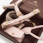 Close-up of the pale pink premium Italian leather dog walking set by CHOUCHOÚ, showcasing solid brass hardware inside a magnetic gift box.