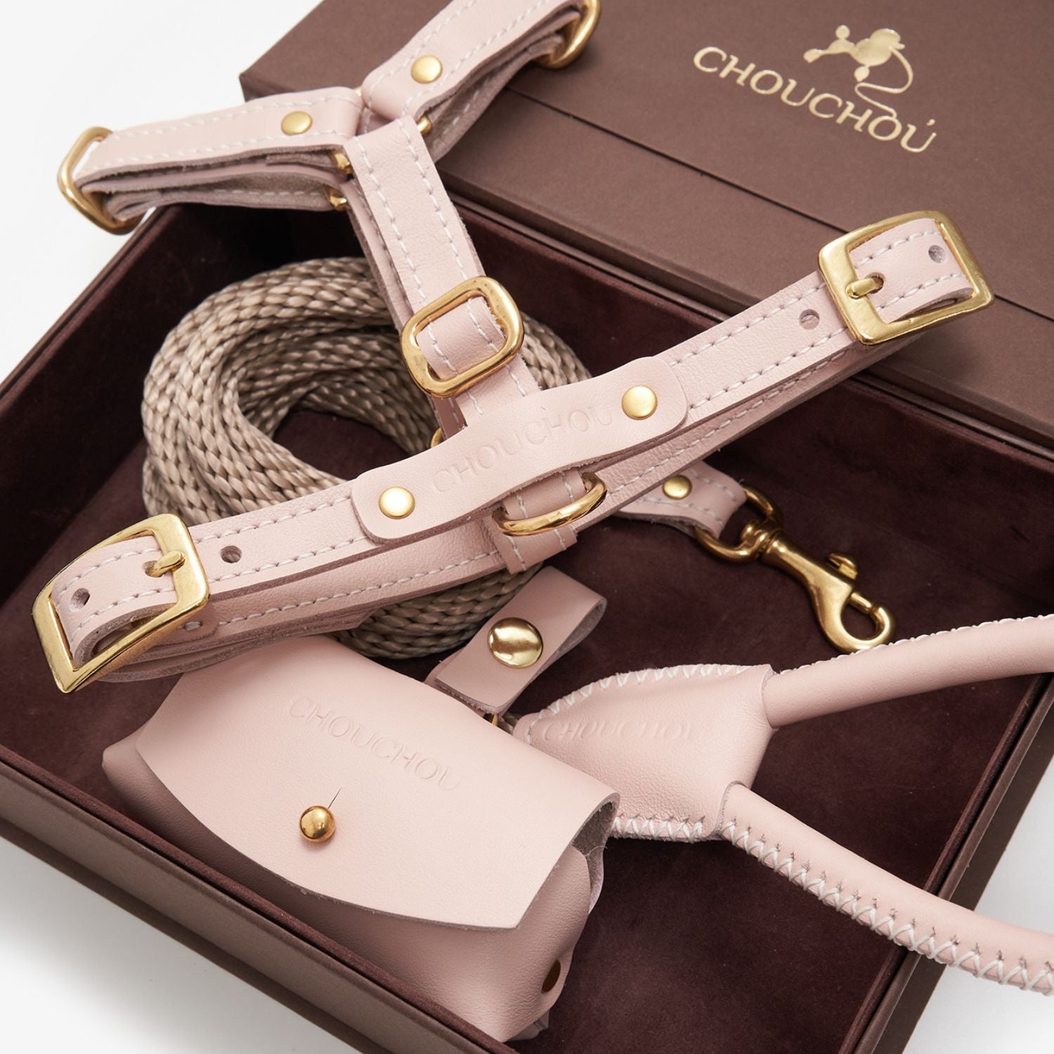 Close-up of the pale pink premium Italian leather dog walking set by CHOUCHOÚ, showcasing solid brass hardware inside a magnetic gift box.